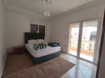 a bedroom with a bed and a large window at Appartement Moderne 3 Chambres in Khemisset