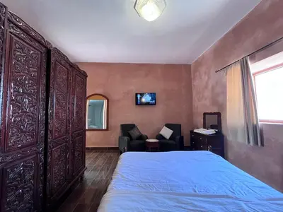 a bedroom with a bed and two chairs and a window at Benyakoub in Mahirija
