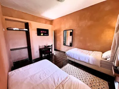 a room with two beds and a tv on the wall at Benyakoub in Mahirija