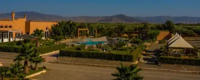 a view of a resort with a pool and trees at Benyakoub in Mahirija