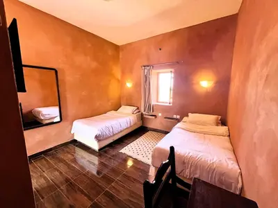 a small room with two beds and a mirror at Benyakoub in Mahirija
