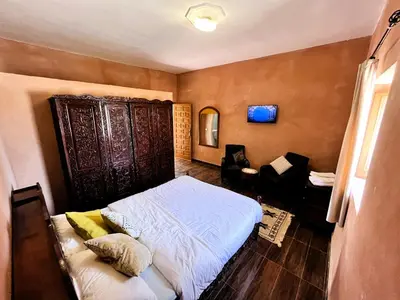 a bedroom with a bed and a chair in it at Benyakoub in Mahirija