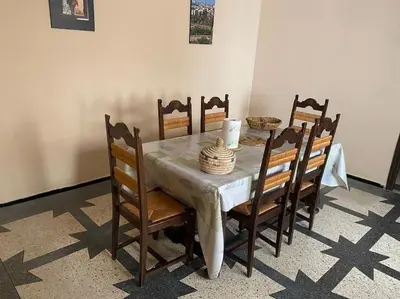 a dining room table with chairs and a white table cloth at Apartment Hamria Central in Meknès