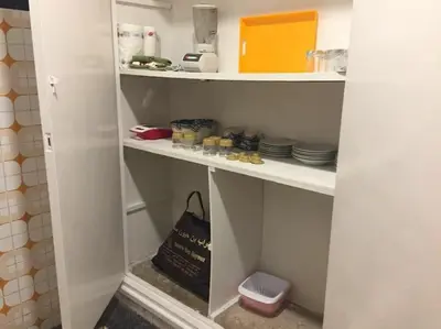 a shelf with dishes and a bag in a kitchen at Apartment Hamria Central in Meknès