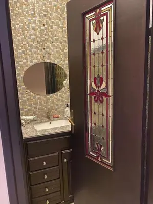 a bathroom with a sink and a door with a mirror at Apartment Hamria Central in Meknès