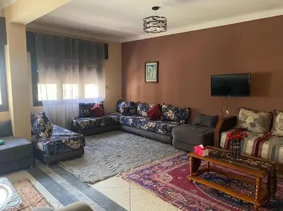 a living room with couches and a flat screen tv at Apartment Hamria Central in Meknès