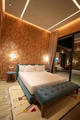 a bedroom with a large bed and a blue bench at Villa Rubis in Marrakech