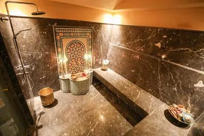 a bathroom with a shower and a tiled wall at Villa Rubis in Marrakech