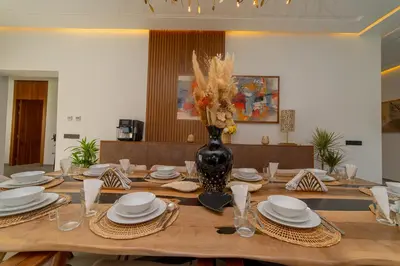 a table with plates and a vase with flowers on it at Villa vue atlas marrakech in Marrakech
