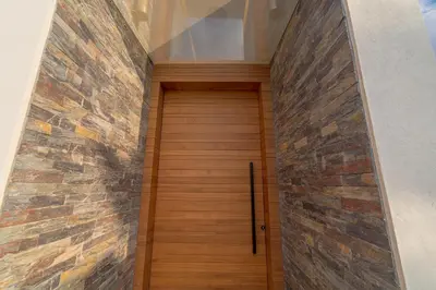 a wooden door in a brick wall at Villa vue atlas marrakech in Marrakech