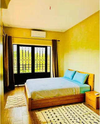 a bedroom with a bed with blue pillows and a window at Villa Nadia Marrakech in Marrakech