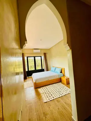 a bedroom with a bed and a large window at Villa Nadia Marrakech in Marrakech