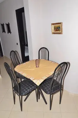 a dining room table with four chairs and a yellow table at Appartement au coeur de Fès in Fès