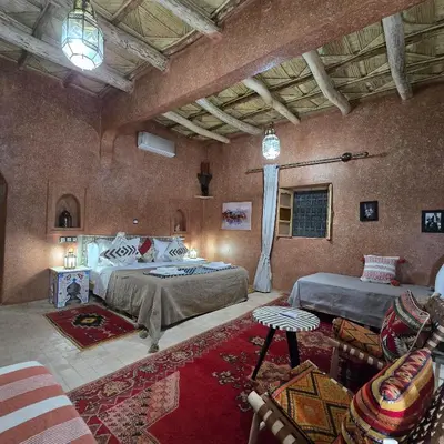 a large bedroom with two beds and a couch at Riad Paradise of Silence in Aït Ben Haddou
