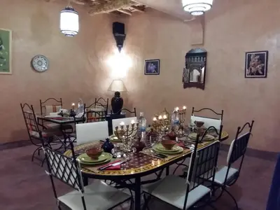 a dining room with a table and chairs with candles at Riad Paradise of Silence in Aït Ben Haddou