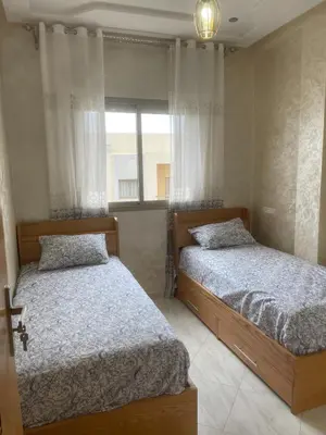 two beds in a bedroom with a window at Housse Fez City in Fès