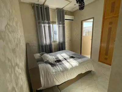 a bedroom with a bed in a room with a window at Housse Fez City in Fès