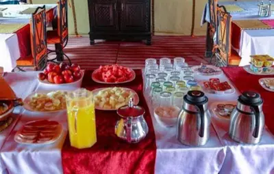 a table with many plates of food and drinks at Sahara Luxury Magic in Hassilabied