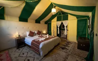 a bedroom with a bed with a green and yellow ceiling at Sahara Luxury Magic in Hassilabied