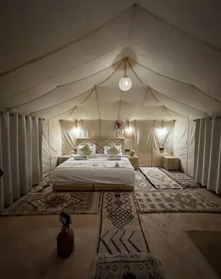 a bedroom with a bed in a tent at Sahara Luxury Magic in Hassilabied