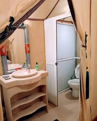 a bathroom with a sink and a toilet in a tent at Sahara Luxury Magic in Hassilabied
