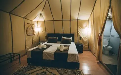 a bedroom with a bed with two stuffed animals on it at Sahara Luxury Magic in Hassilabied