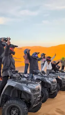 a group of people standing on atvs in the desert at Sahara Luxury Magic in Hassilabied