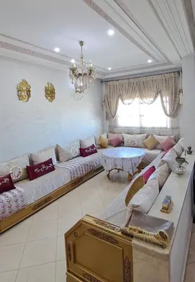 a living room with a large couch and a table at Appartement Calme et Jolie près de l'aéroport in Oulad Tayeb