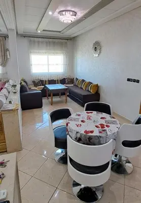 a large living room with a table and chairs at Appartement Calme et Jolie près de l'aéroport in Oulad Tayeb