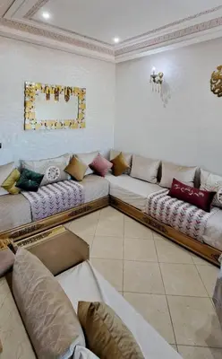 a living room with two long couches in a room at Appartement Calme et Jolie près de l'aéroport in Oulad Tayeb