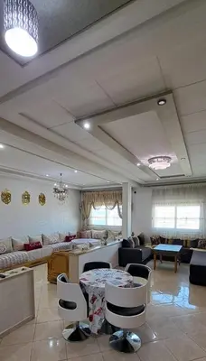 a large living room with a table and chairs at Appartement Calme et Jolie près de l'aéroport in Oulad Tayeb
