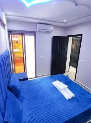 a bedroom with a blue bed with a white pillow on it at Meknes Luxe & Comfort in Meknès