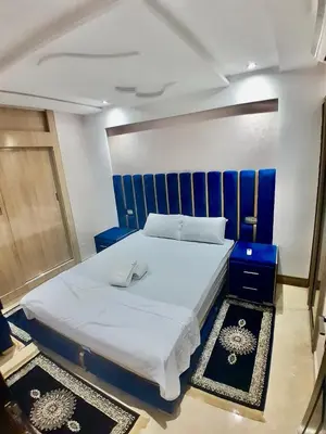 a bedroom with a large white bed with a blue headboard at Meknes Luxe & Comfort in Meknès