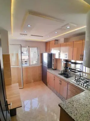 a kitchen with stainless steel appliances and wooden cabinets at Meknes Luxe & Comfort in Meknès