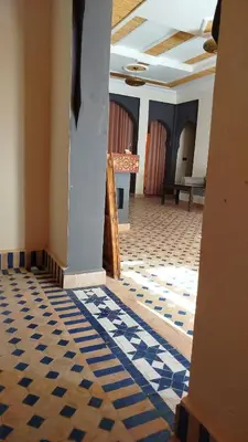 a hallway with blue and white tiled floors in a building at Luxury Camp in Merzouga