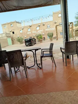 a table with chairs in front of a building at Luxury Camp in Merzouga