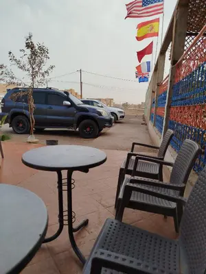 a patio with tables and chairs and a truck at Luxury Camp in Merzouga