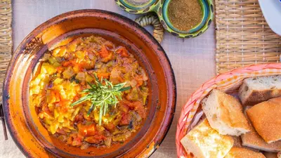 a bowl of food on a table with bread at Riad Kasbah des Roches in Akhendachou nʼAït Ouffi