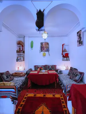 a living room with a table and a couch at Riad Kasbah des Roches in Akhendachou nʼAït Ouffi