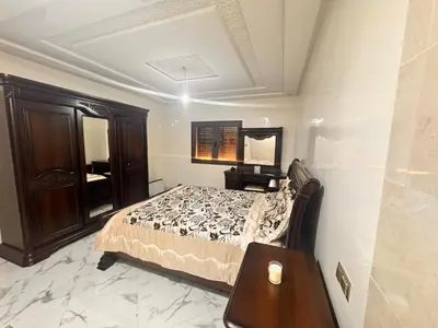 a bedroom with a bed and a table and a mirror at Riad El Menzeh in Meknès
