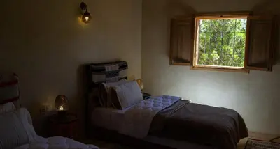 a bedroom with two beds and a window at Auberge Mounia in Telouet