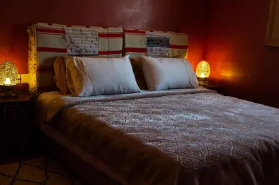 a bedroom with a large bed with two lamps at Auberge Mounia in Telouet