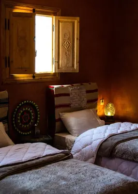a bedroom with two beds and a window at Auberge Mounia in Telouet