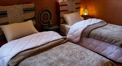 two beds sitting next to each other in a room at Auberge Mounia in Telouet