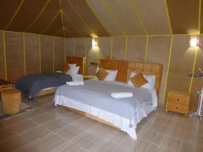 a bedroom with two beds in a tent at lenas desert camp merzouga in Merzouga
