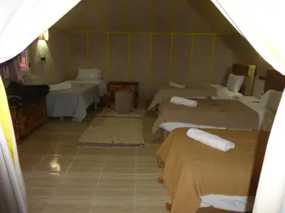 a room with four beds in a room with at lenas desert camp merzouga in Merzouga