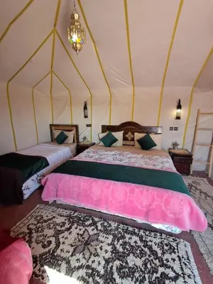 a bedroom with two beds in a tent at lenas desert camp merzouga in Merzouga