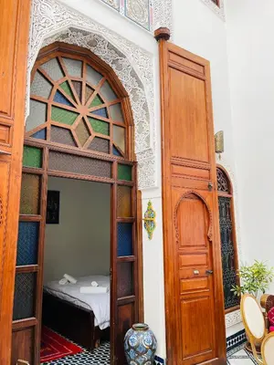 a room with a bed and a wooden door at Riad Fes Miracle in Fès al Bali