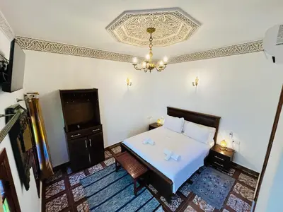 a bedroom with a bed and a chandelier at Riad Fes Miracle in Fès al Bali
