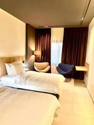 a hotel room with a bed and a chair at Hôtel Le Manoir in Taza